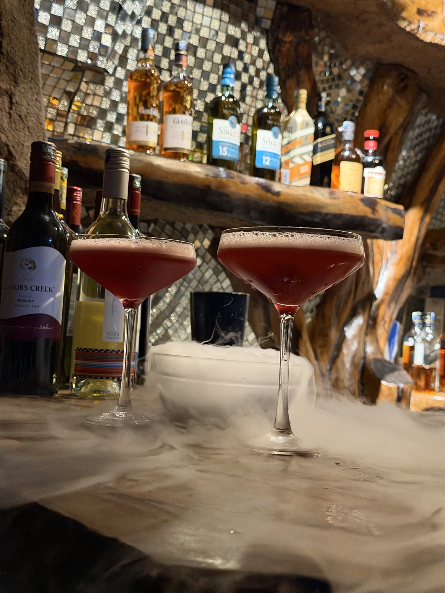 Two signature cocktails served over dry-ice mist at the rock-walled Mawimbi Jiko bar