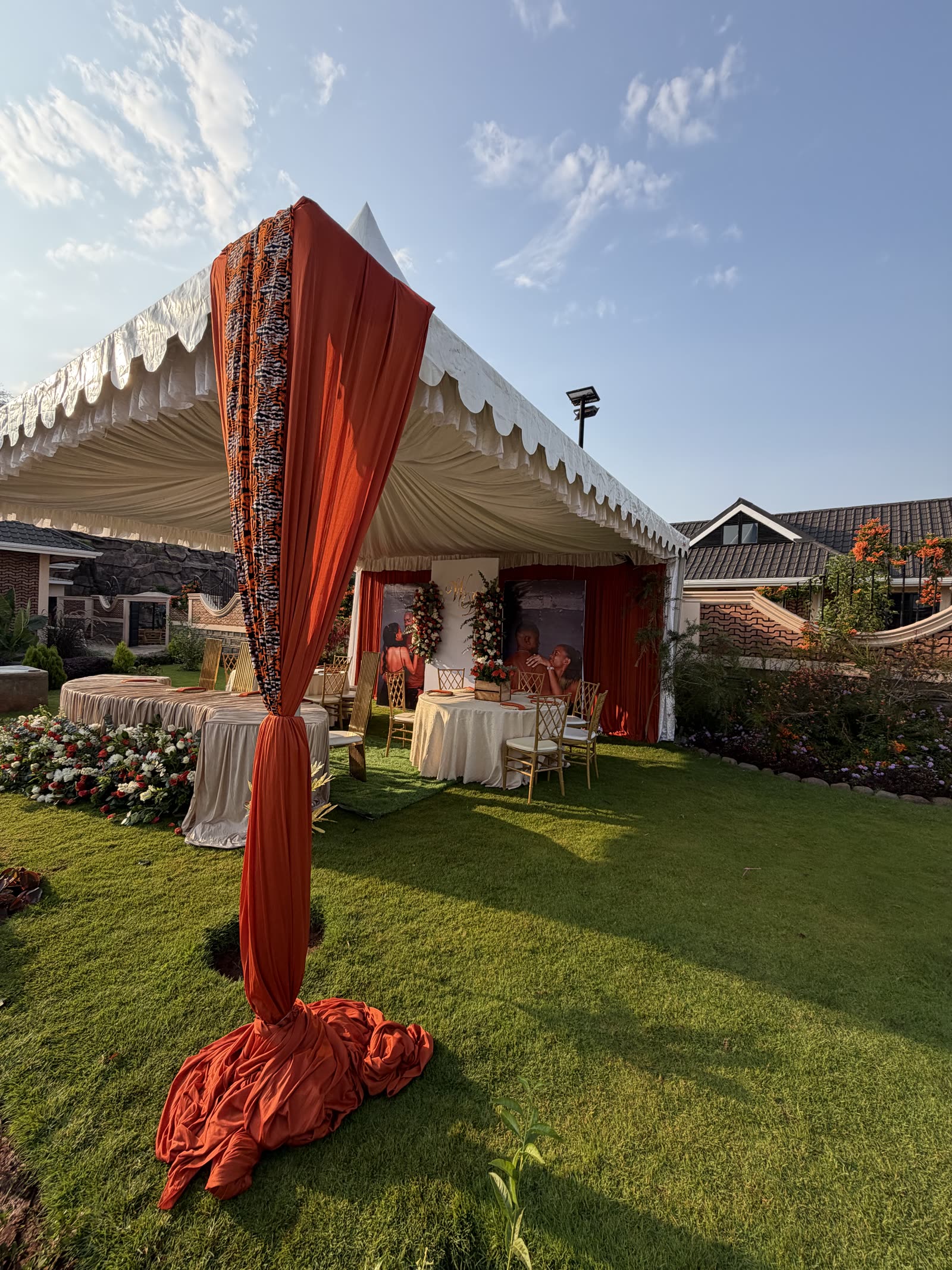 Garden marquee dressed in cream and terracotta drapes with floral tables for a wedding at Mawimbi Jiko