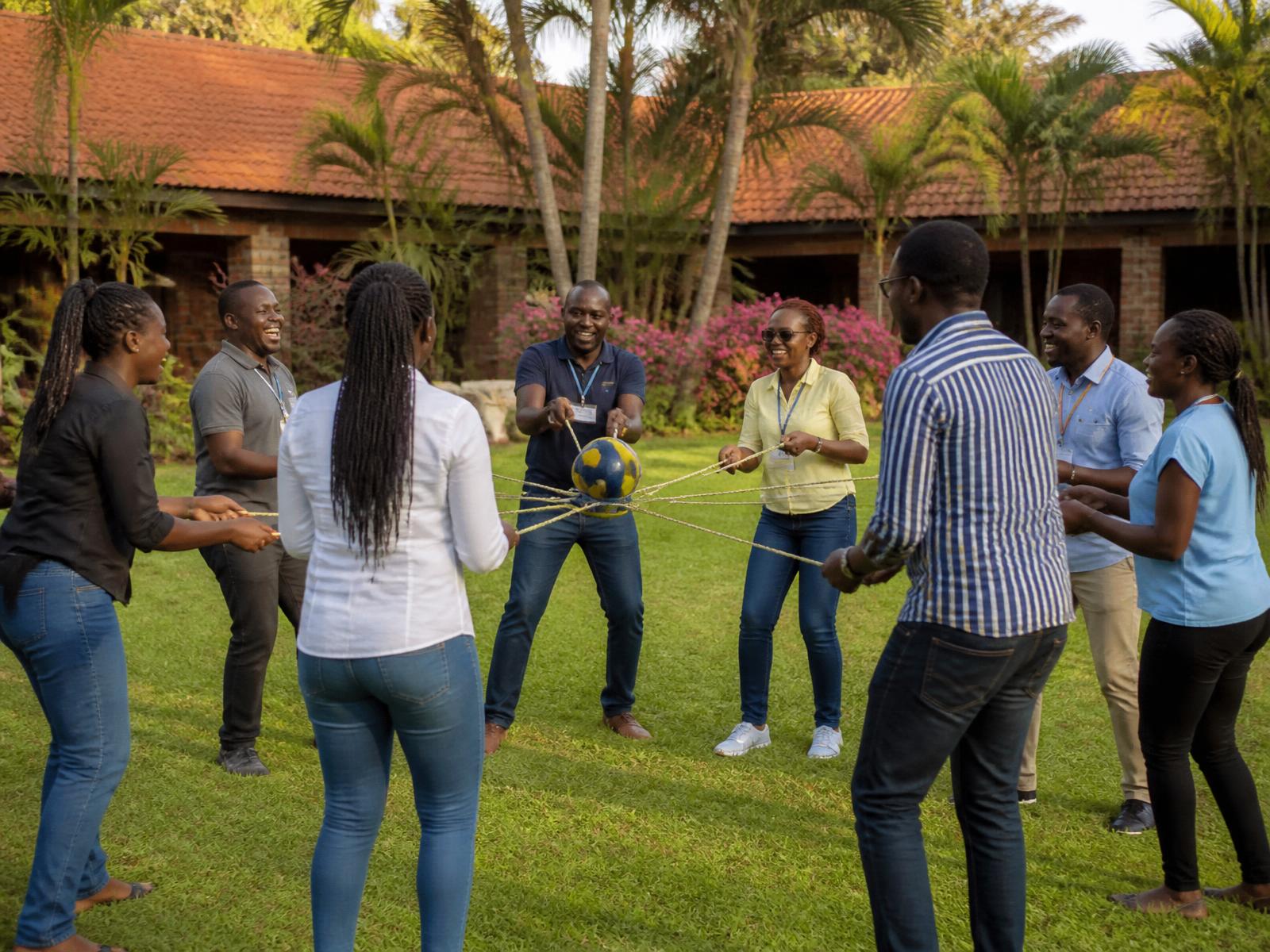 Colleagues playing an outdoor team-building game on the lawn at Mawimbi Jiko