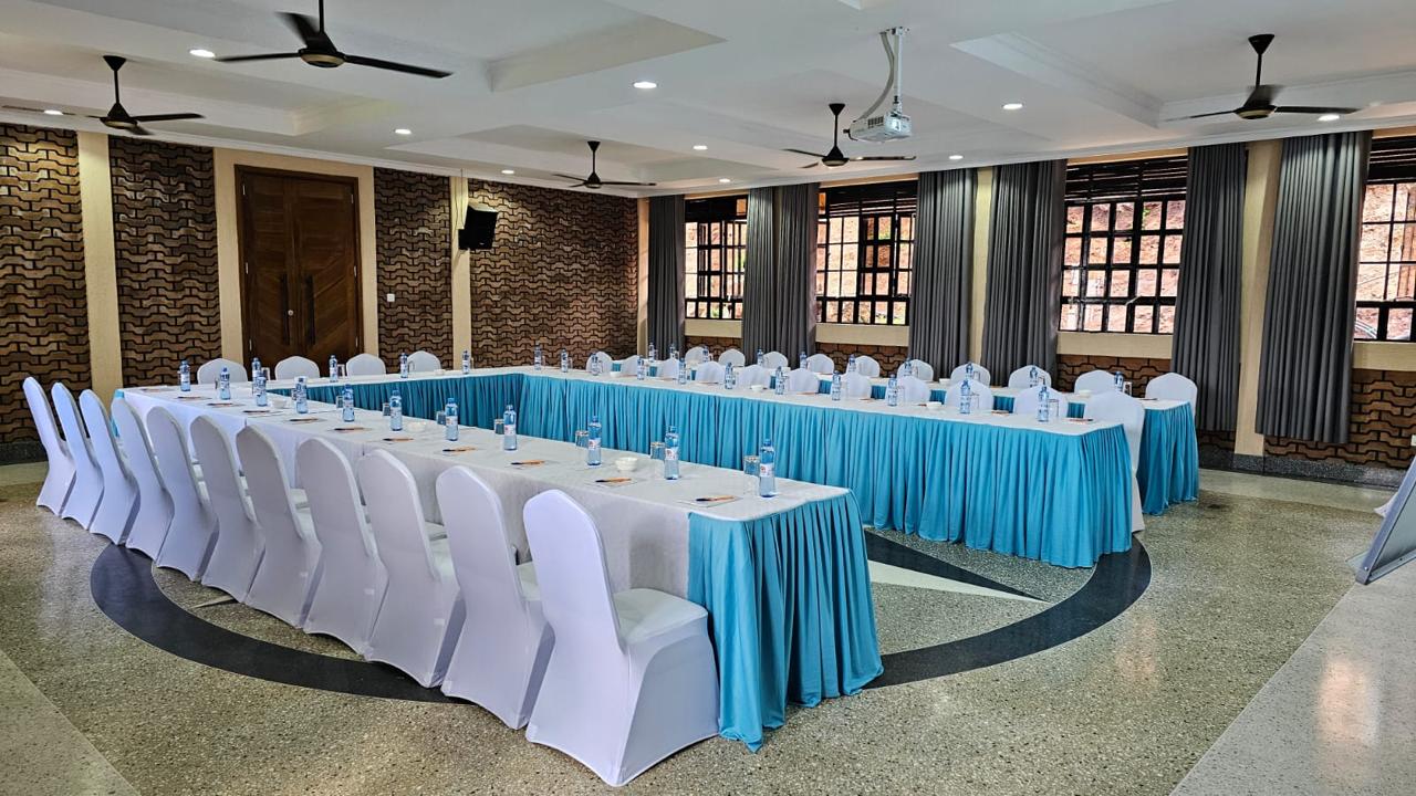 Conference hall arranged in a U-shape with skirted tables and covered chairs