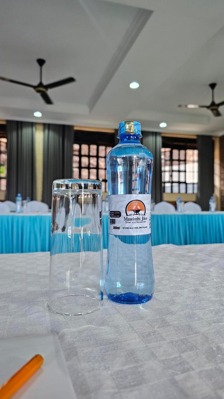 Branded Mawimbi Jiko 500ml mineral water and glass on a delegate table
