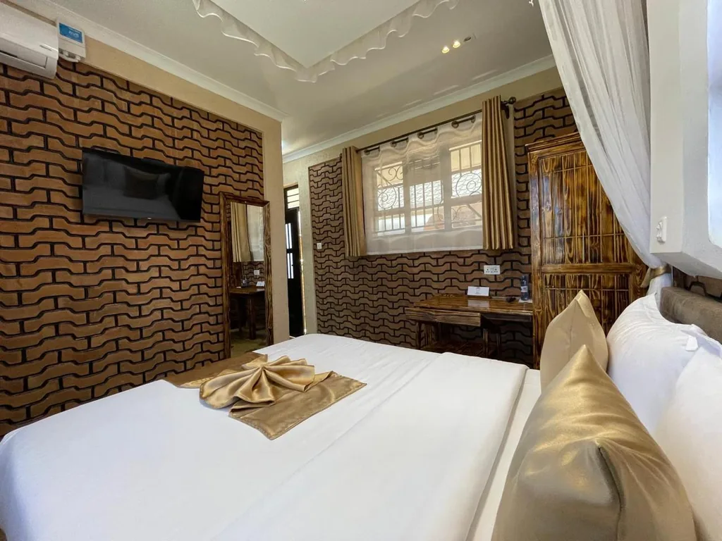 Guest room with the signature Mawimbi wave-patterned brick wall, Smart TV and work desk
